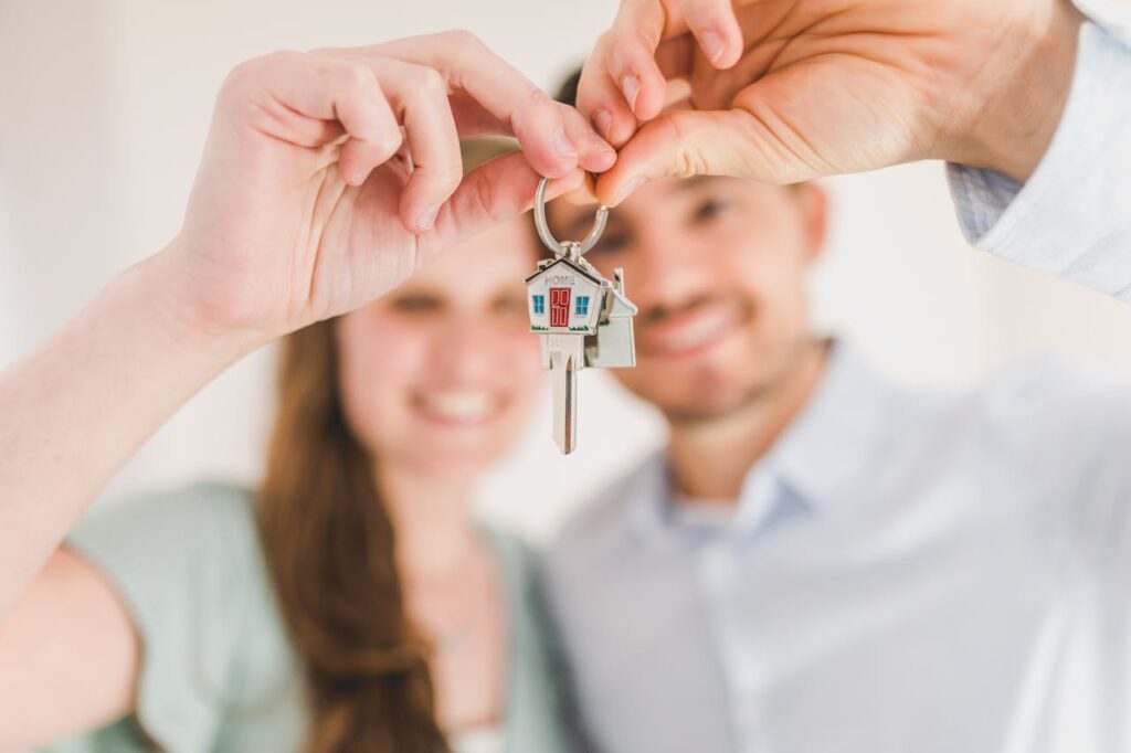 A couple is holding a key to their new home. 