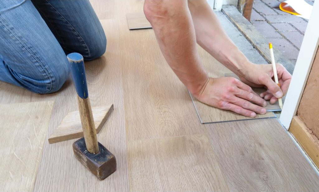 A contractor, who has been hired by a real estate investor with a fix-and-flip loan, is installing new floors. 