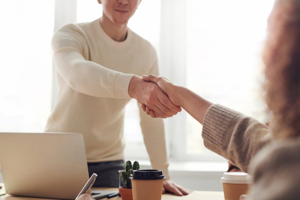 A lender is shaking their client's hand after closing a deal on an investment property. 