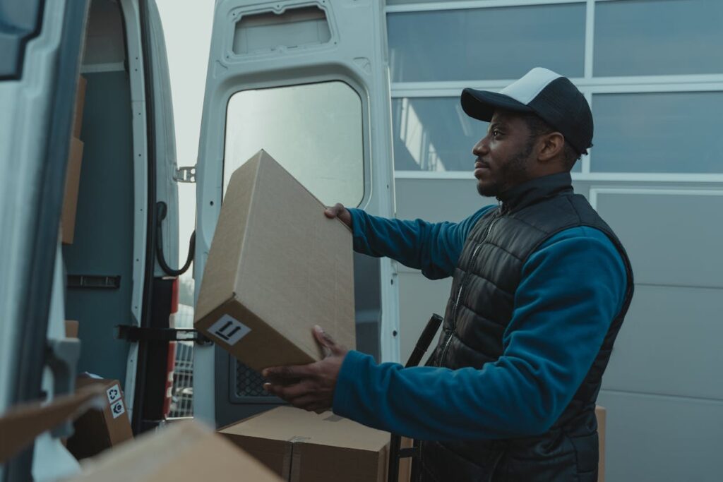 A gig worker, who is an ideal candidate for a Colorado bank statement loan, is taking packages out of a van.