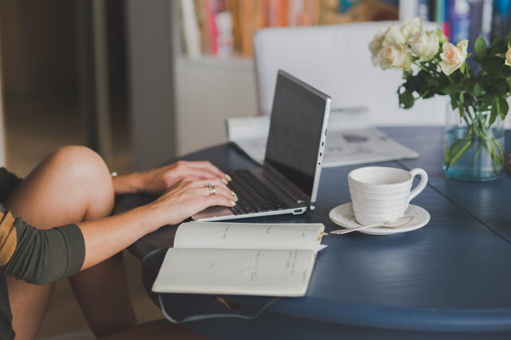 A woman is researching the pros and cons of DSCR loans on her laptop while having a cup of coffee.