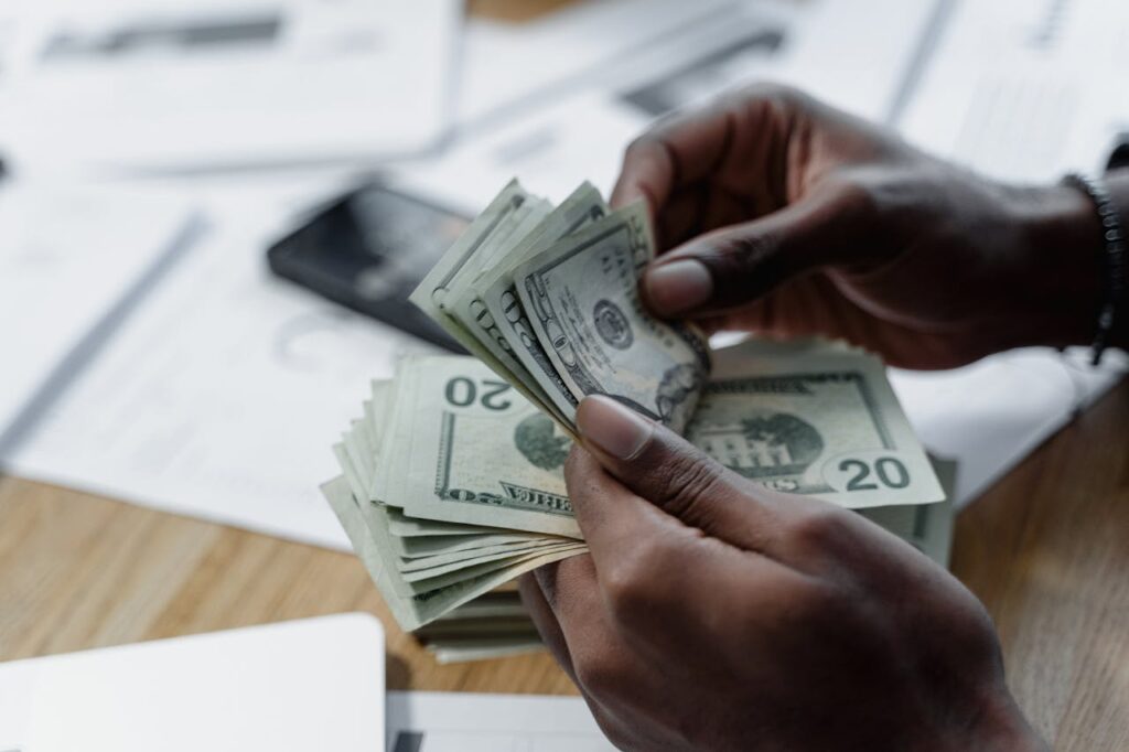 A person is counting the bills they got from a cash-out refinance for investment properties. 