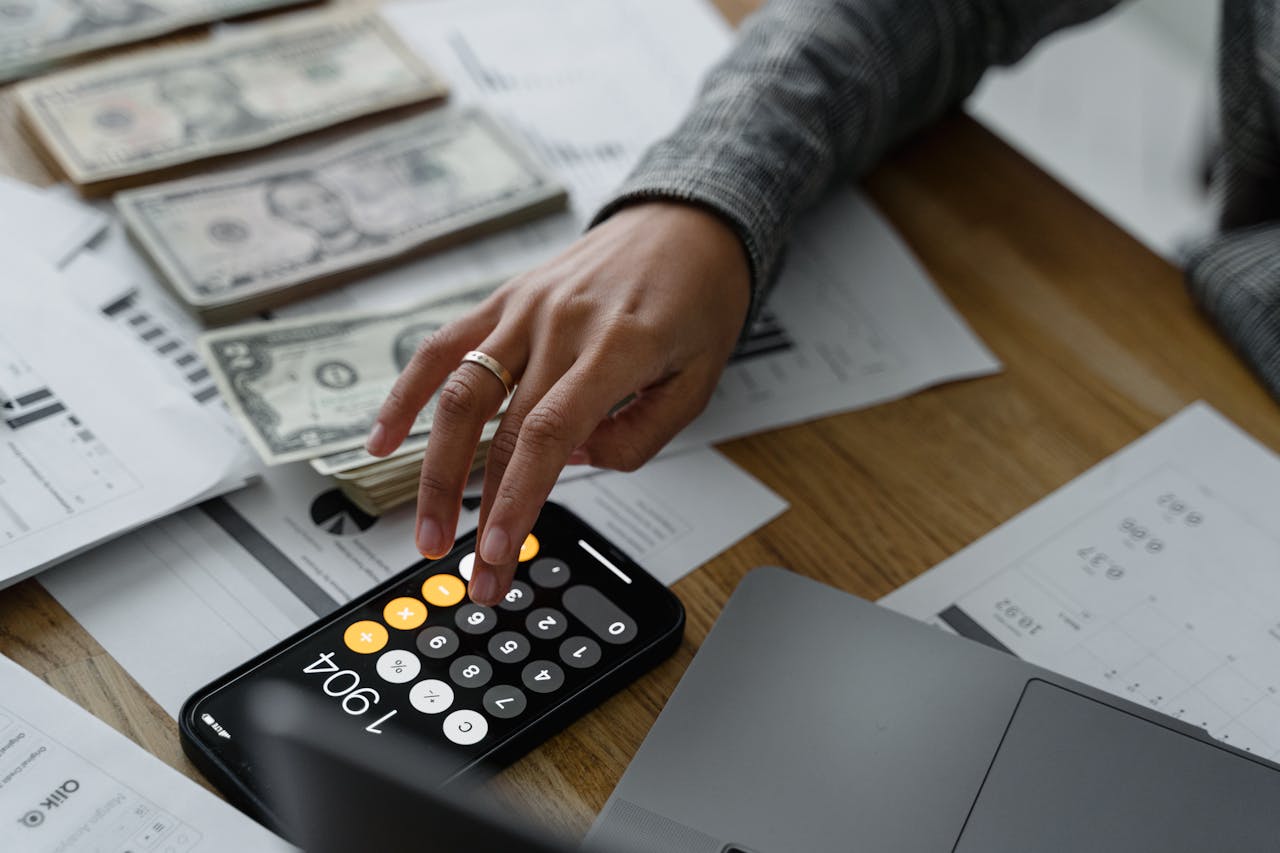 A woman is using her iPhone calculator to determine how much she can get from a DSCR cash-out refinance.