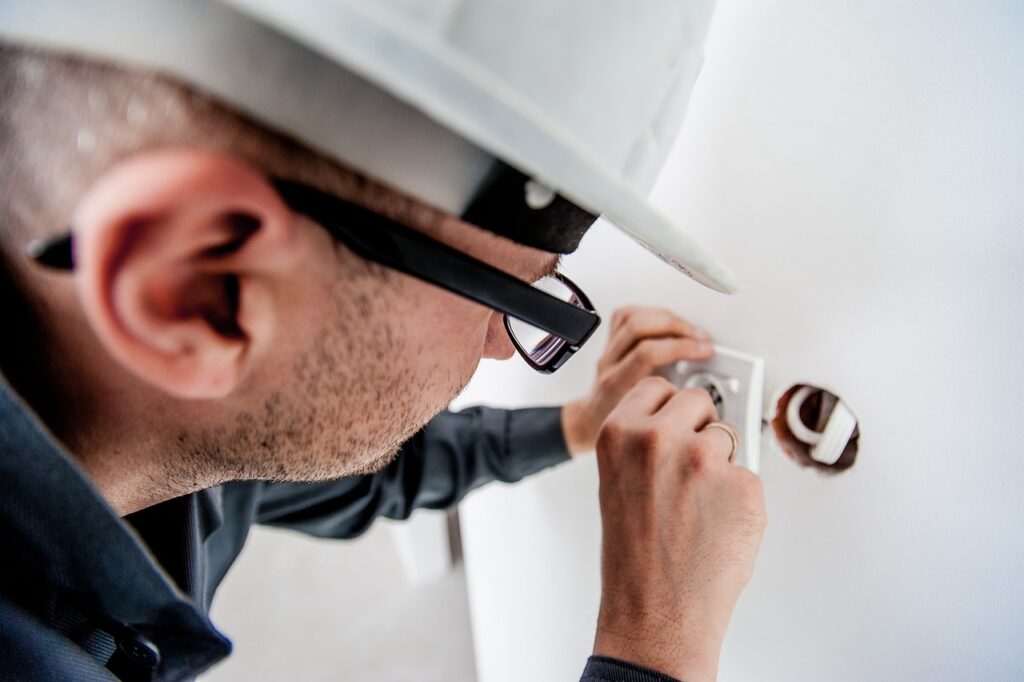 An electrician is fixing wiring on a home that was purchased with DSCR loans for property investment. 