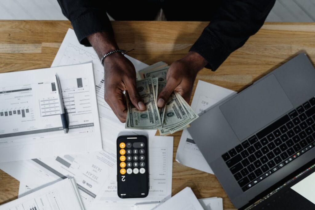 A man counting cash to pay his bills since he knows that paying bills on time will improve your credit score. 