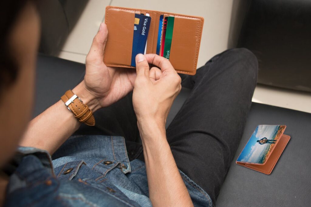 A man is looking through his wallet to grab his credit card. 