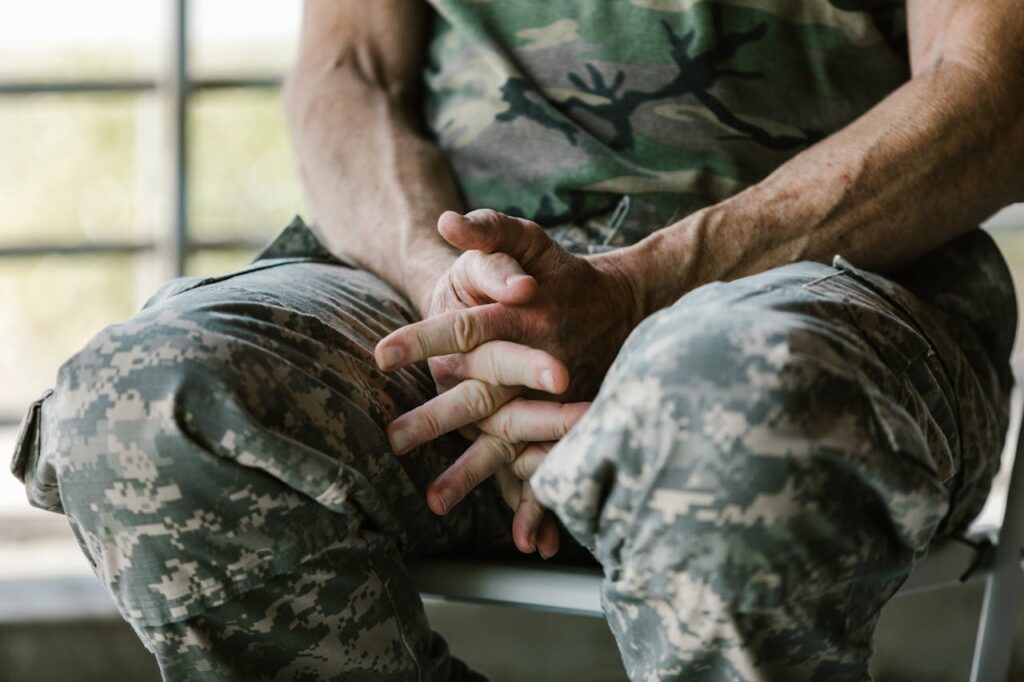 An active-duty military individual is holding his hands anxiously while waiting for interest rate cuts. 