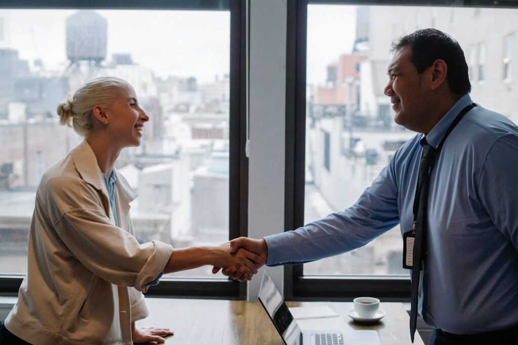 A customer is shaking hands with a loan officer after debunking myths about self-employed mortgages and finally closing on a home. 