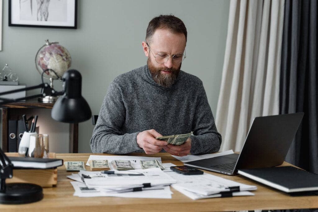 A real estate investor is doing his calculations to make sure he can afford the down payment for his DSCR loan Connecticut. 