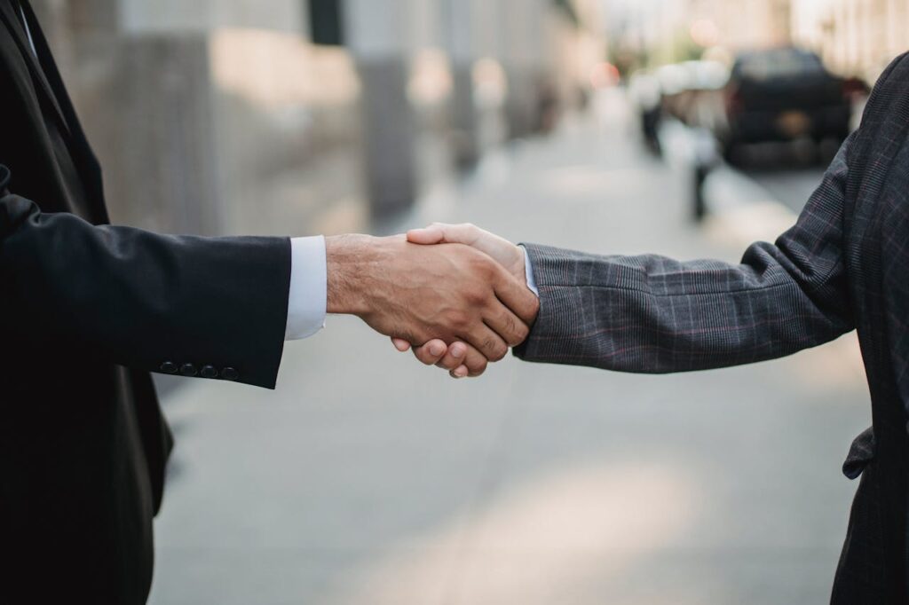 Real estate investors shaking hands after making an investment using a construction loan Oregon. 