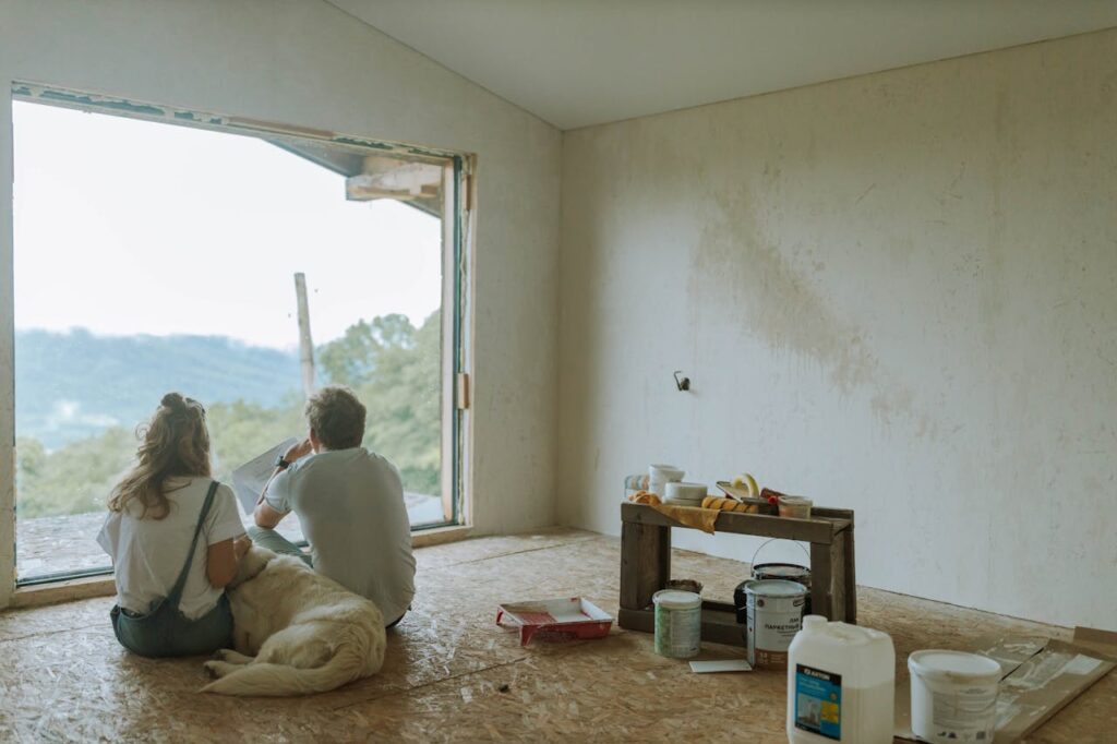 A couple sitting in their half-finished new build home that was purchased with a construction loan Georgia. 