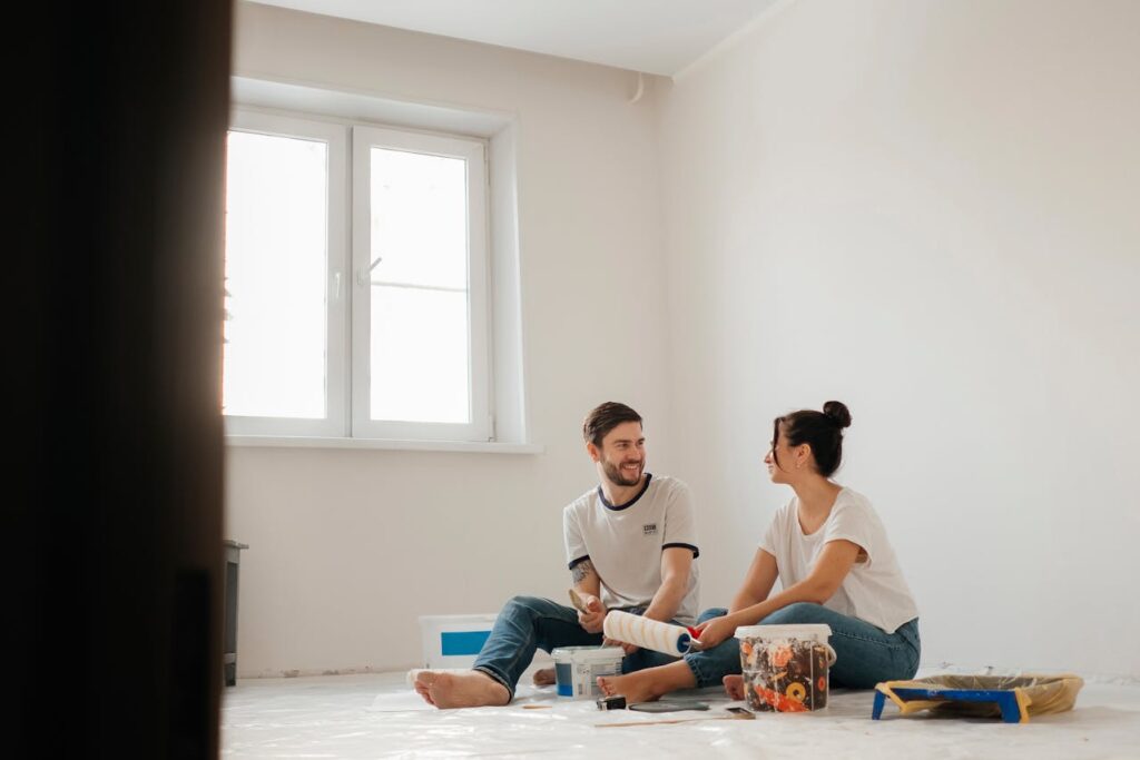 A couple is painting their newly built dream home after financing it with a construction loan Texas.