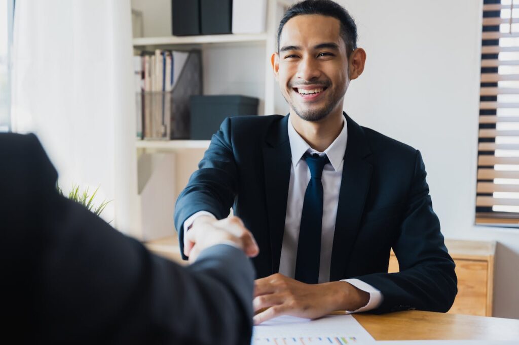 A mortgage loan officer is shaking a client's hand after closing the deal on their new jumbo loan Georgia home. 