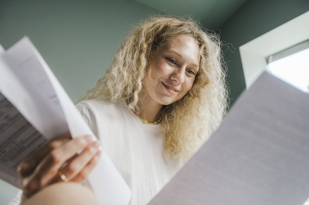 A young woman is looking through her DSCR loan Iowa pre-approval letter to check her interest rate. 