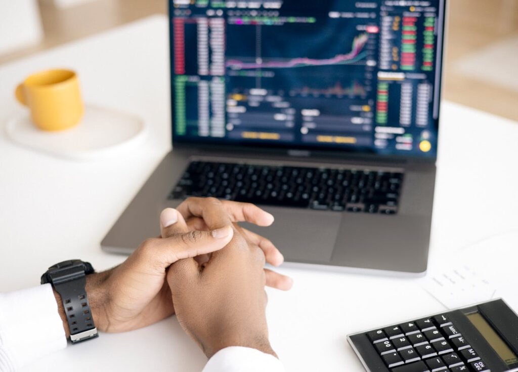 An investor sits in front of his computer, reviewing his stock portfolio. 