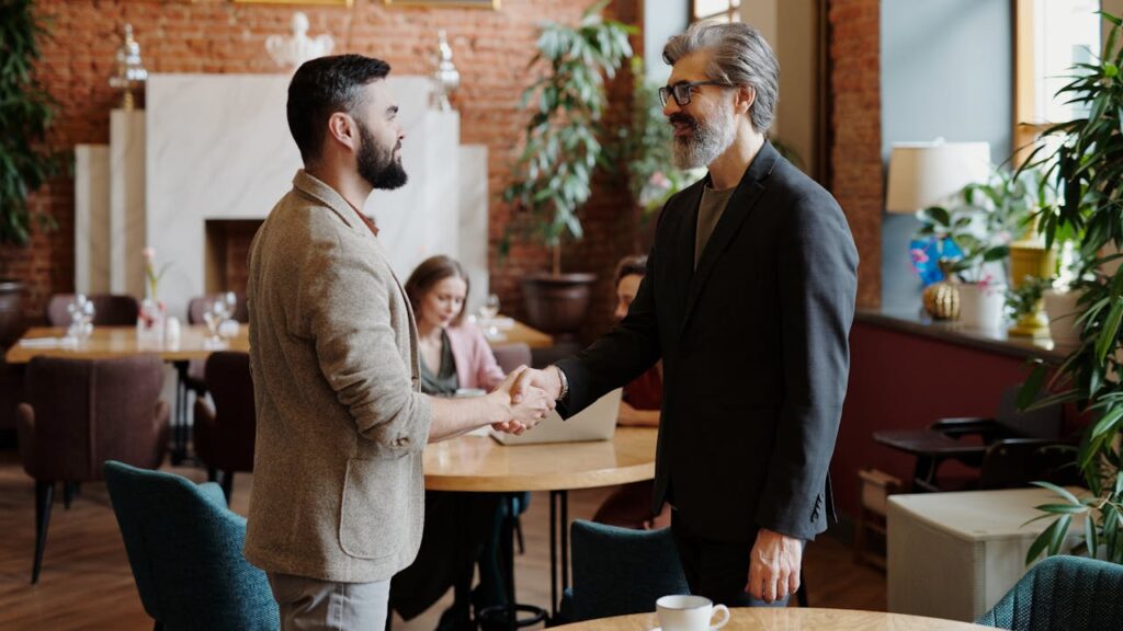 A loan officer is shaking hands with a client after closing on a DSCR loan Kansas. 